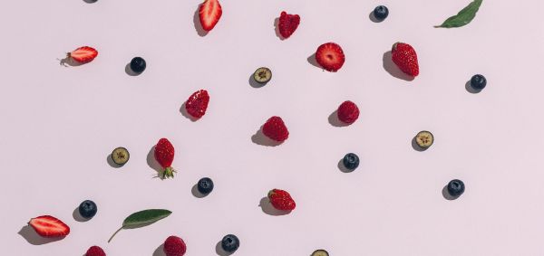 Cut fruits arranged in front of a white background