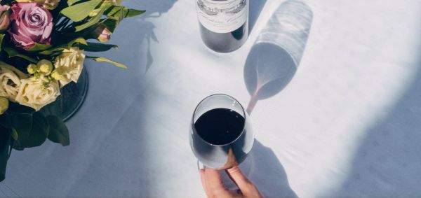 Glasses of Château Canon red wine and bouquet of flowers on a table